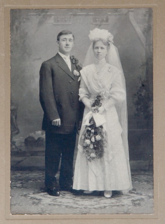 Mulher posando ao lado do seu marido por volta de 1900.