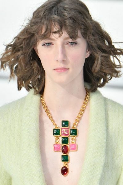 Foto de Modelo com colar Chanel, trabalhado com correntes e pedras coloridas.