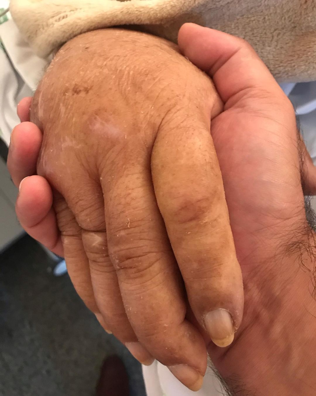 João Lacerda Neto segurando a mão do pai em hospital, o Brasil chora sua partida.