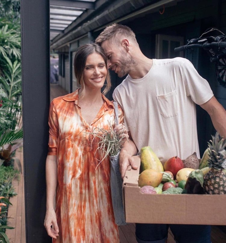Sorrindo, Fernanda Lima e Rodrigo Hilbert posam com frutas, legumes e verduras