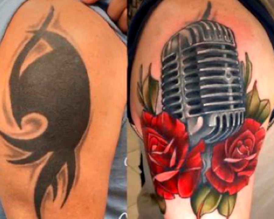 Cobertura de uma tatuagem preta, com outra de um microfone colorido cercado por rosas vermelhas.