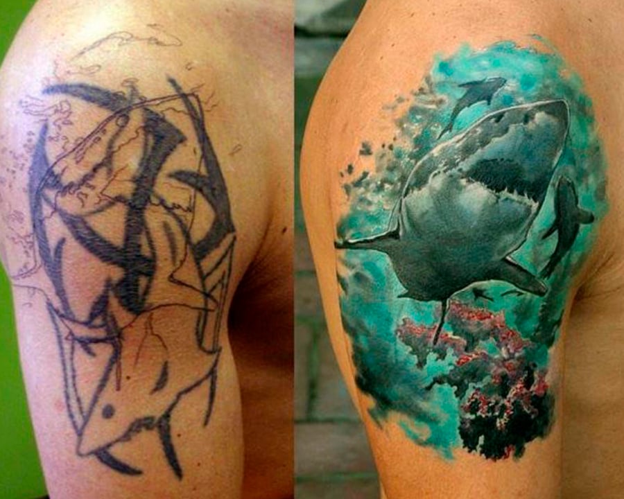 Tatuagem de um tubarão colorido cobre outra de um tubarão feita em preto.
