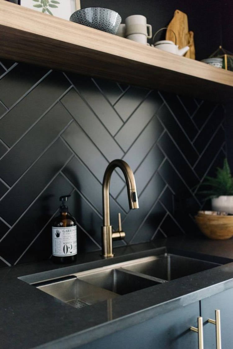 Cozinha preta com azulejo.