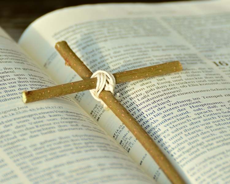 Foto de bíblia e pequena cruz de gravetos.