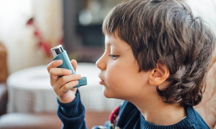 Menino usando bombinha no Dia Mundial da Asma.