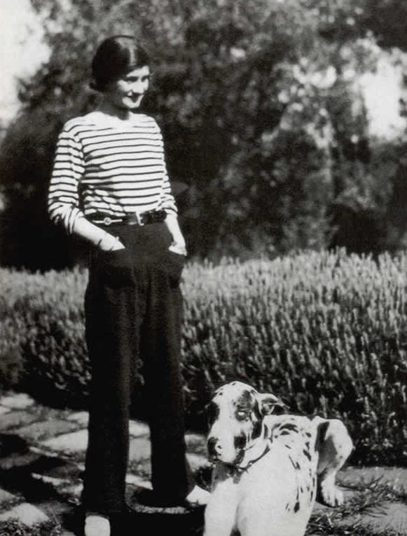 Coco Chanel posando ao lado de um cachorro