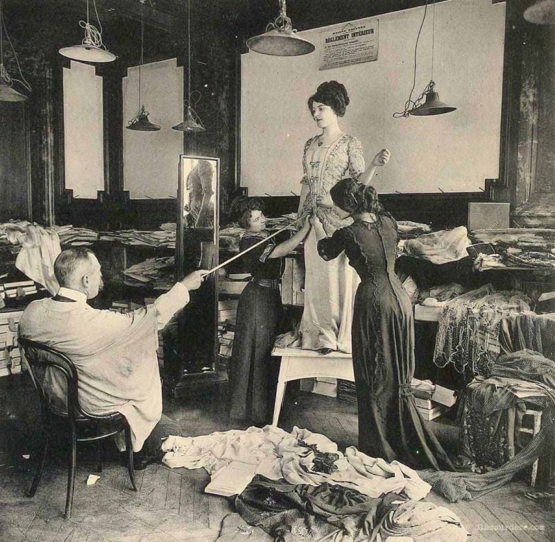 Mulher prova um vestido em um ateliê de costura