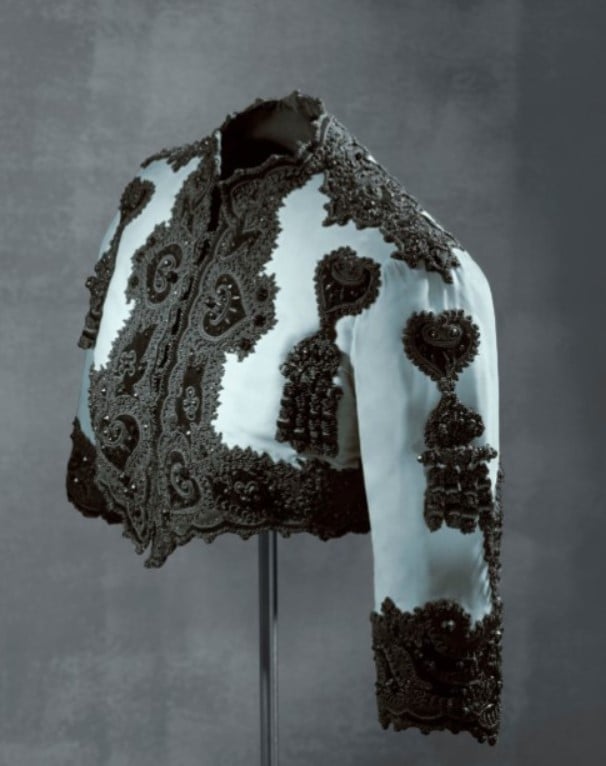 Jaqueta curta em estilo toureiro com seda azul e decoração em preto de Cristóbal Balenciaga. 