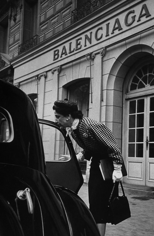 Editora da Vogue Bettina Ballard diante da Maison Balenciaga. 