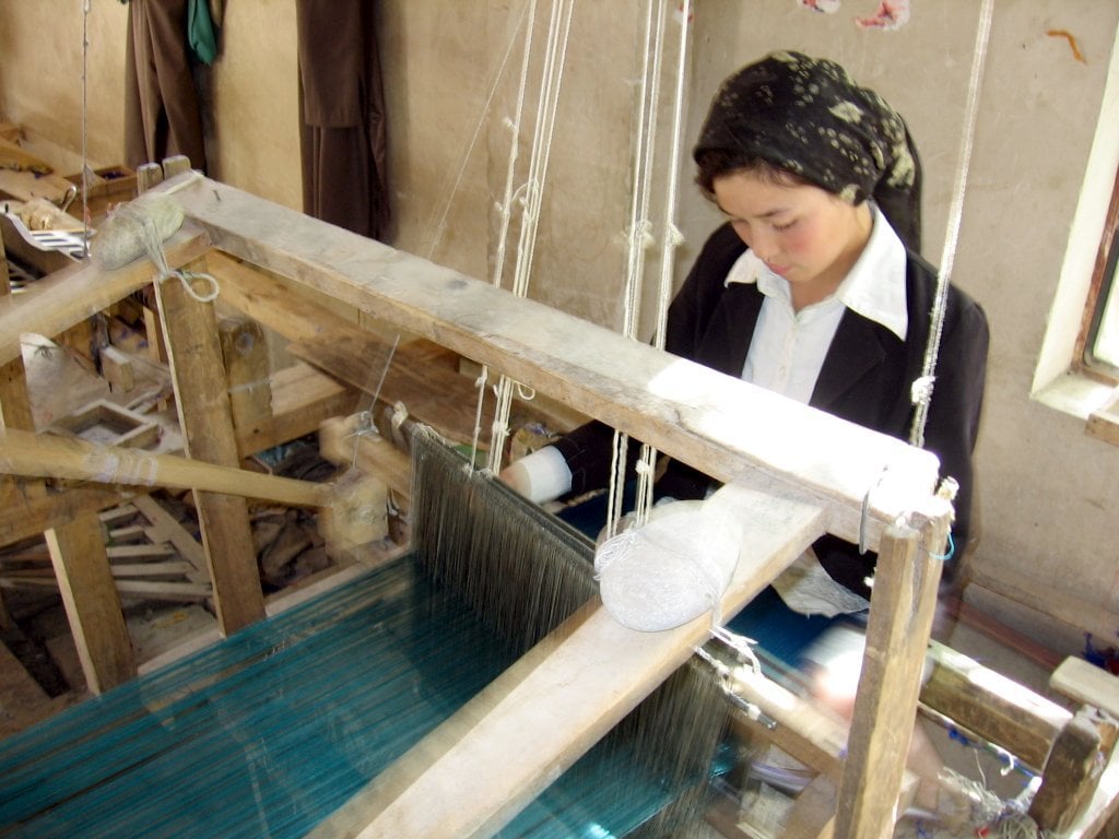 Tecelã trabalhando a seda em Khotan, na China. 