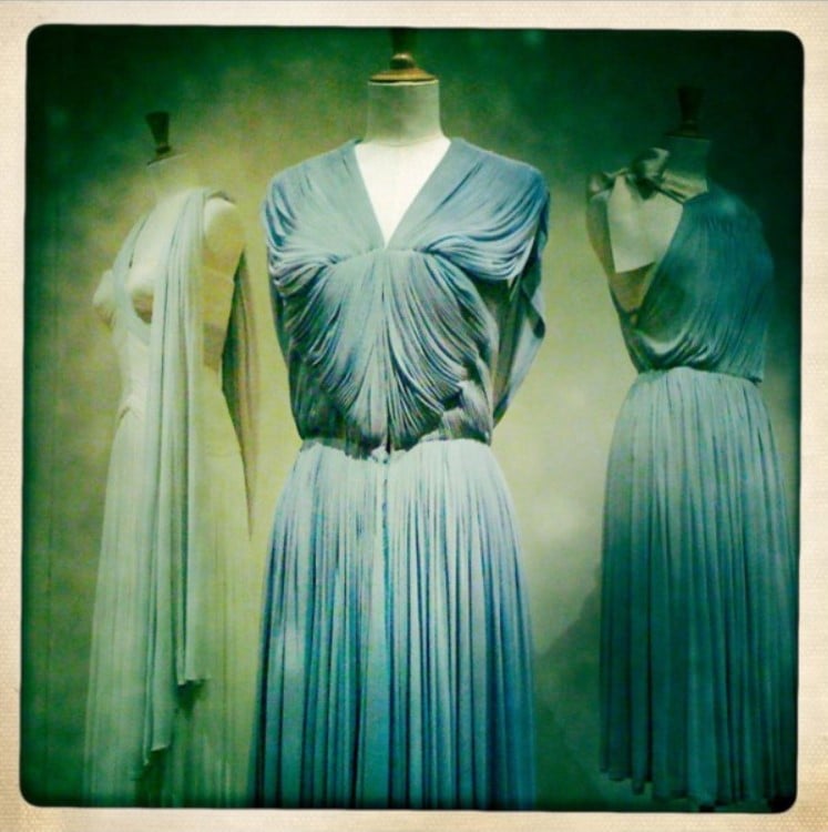 Exposição com manequins com vestidos drapeados de Madame Grès. 