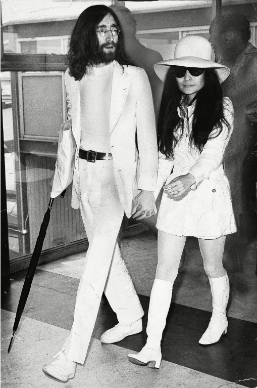 Yoko Ono com um vestido de noiva branco curto e John Lennon no dia do seu casamento, em 1969.