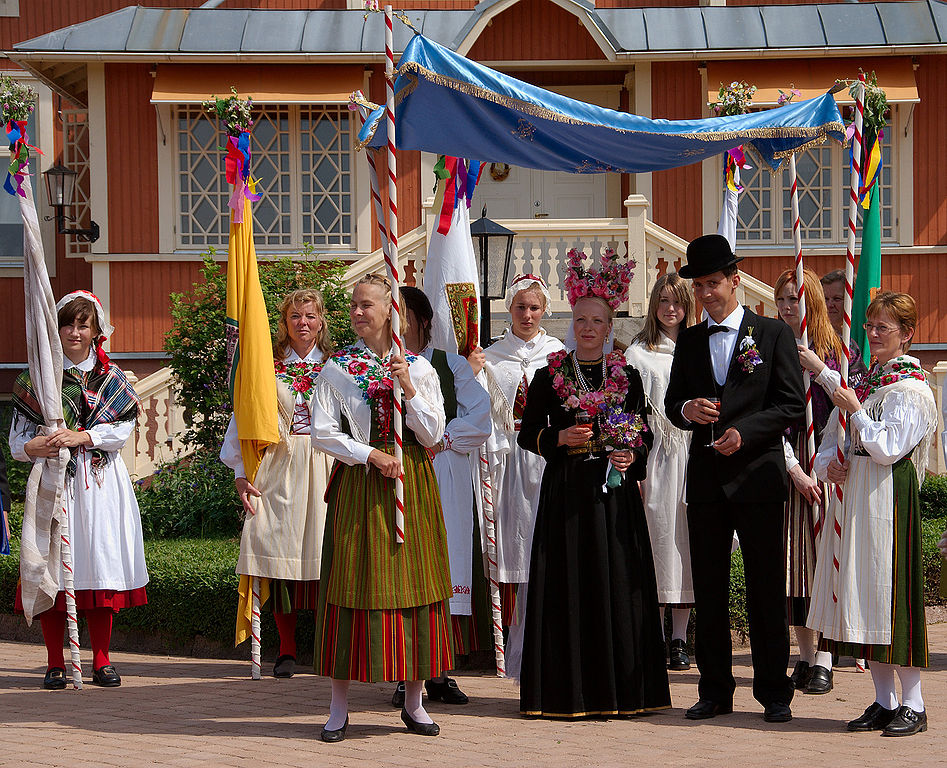 Festa de casamento em Jomala, interior da Finlândia, onde se vê um vestido de noiva preto ornamentado com flores. 