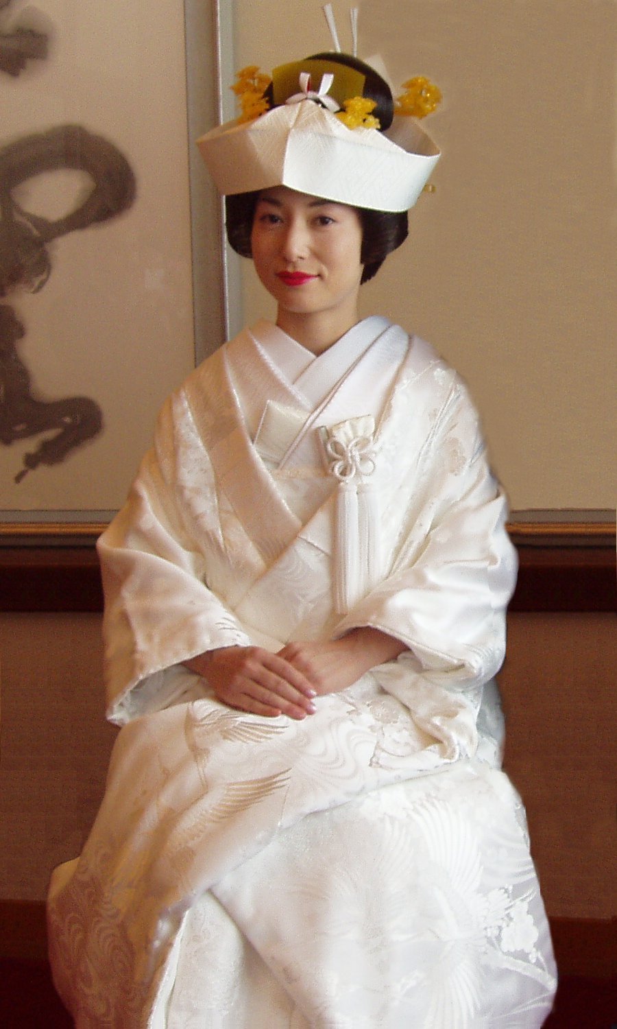 Mulher japonesa sentada com um quimono de casamento branco e chapéu. 