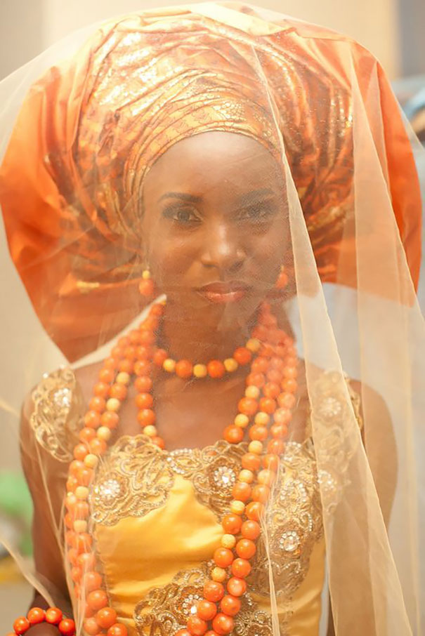 Foto de uma noiva nigeriana com um vestido laranja e turbante. 