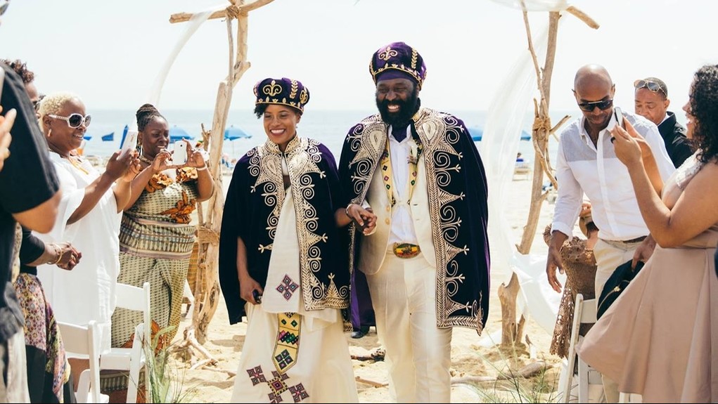 Casal em uma cerimônia ao ar livre com traje de casamento tradicional da Eritreia.