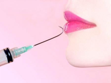 Injeção com ponta da agulha virada apontando para lábios de mulher