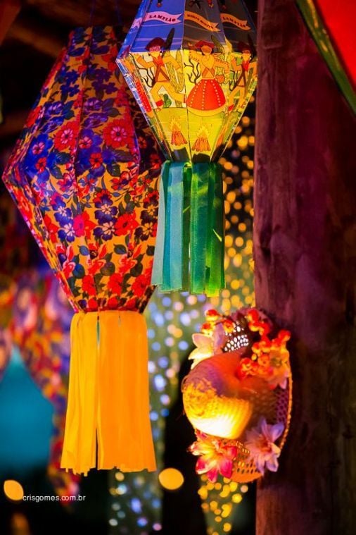 A imagem representa decorações de festa junina: balões grandes feitos de tecido e fita de cetim