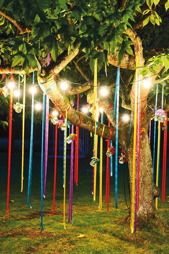 árvore decorada com fitas de cetim e luzes para festa junina