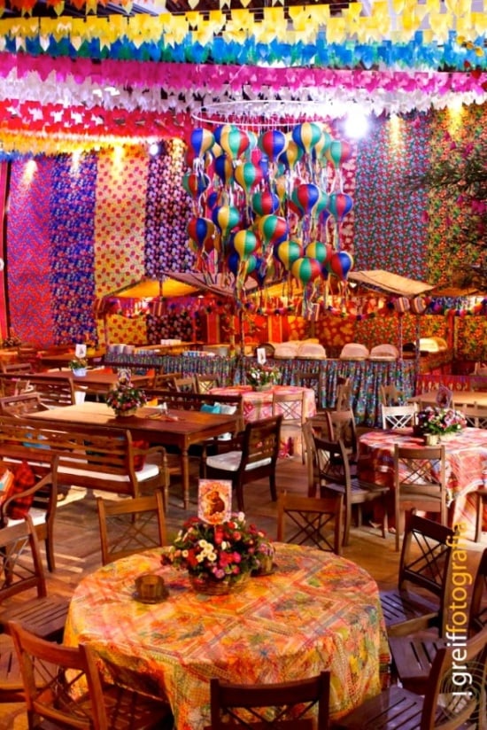 festa luxuosa junina, colorida, com balões e mesas espalhadas