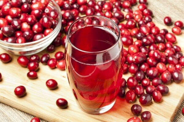 Foto de frutos Cranberry e copo de suco da fruta