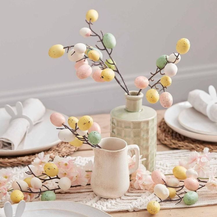 Mesa posta com enfeites de ovo de Páscoa em tons pastéis