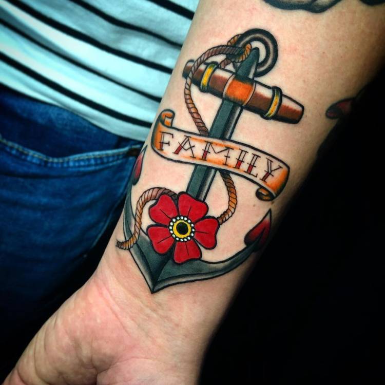 Tatuagem old school de âncora com flor e faixa escrito "family"