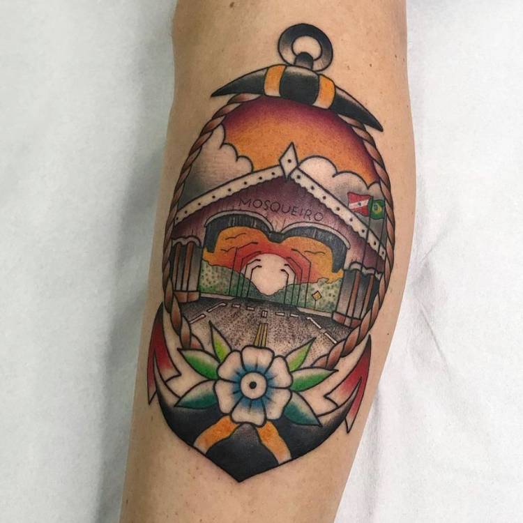 Braço de pessoa de pele clara tatuado com âncora e paisagem de Mosqueiro old school