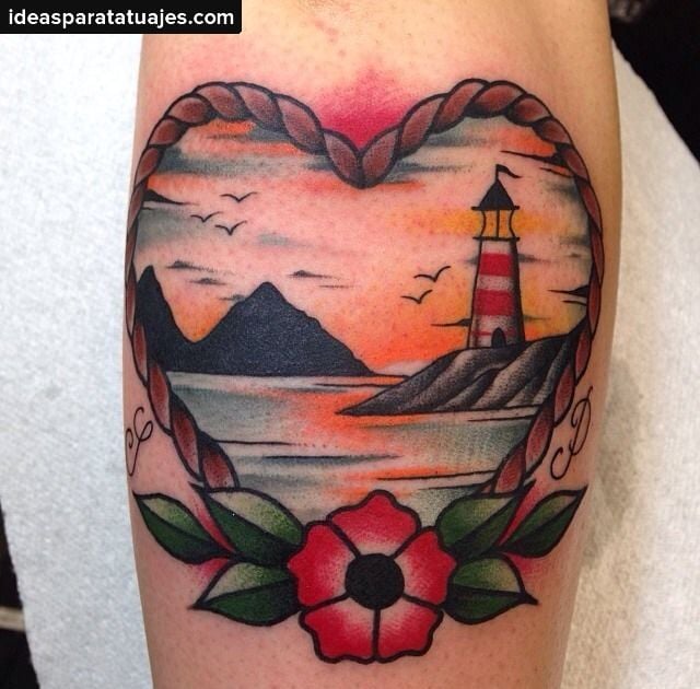 Tatuagem de paisagem do mar com montanhas e farol dentro de um coração de corda com flores ao redor.