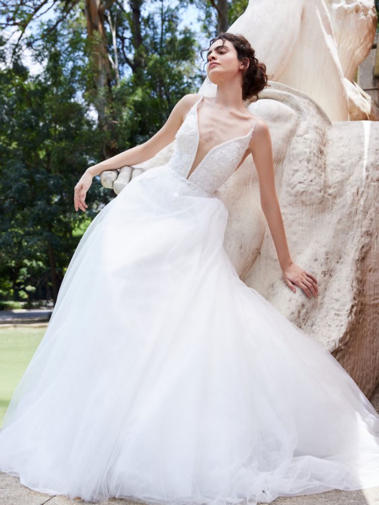 Mulher de pele clara usando vestido de noiva com brilho no busto e saia volumosa