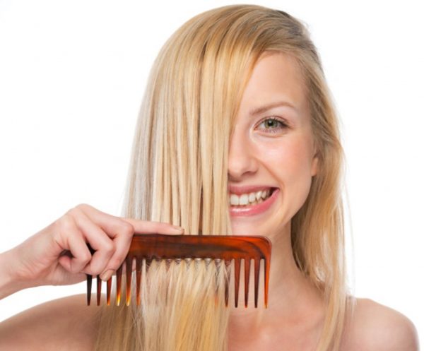 Mulher loira com pente no cabelo liso - Como lavar os cabelos corretamente