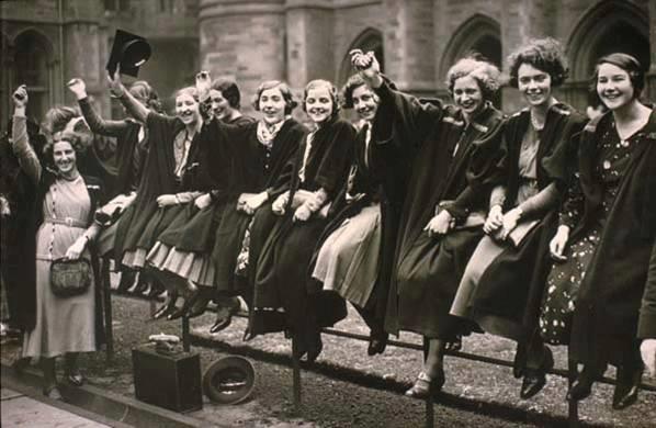 mulheres em foto preto e branco sentadas em grade comemorando