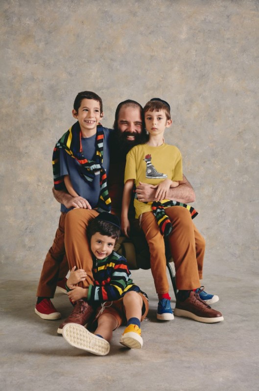 Um pai e seus três filhos judeus usando roupas coloridas