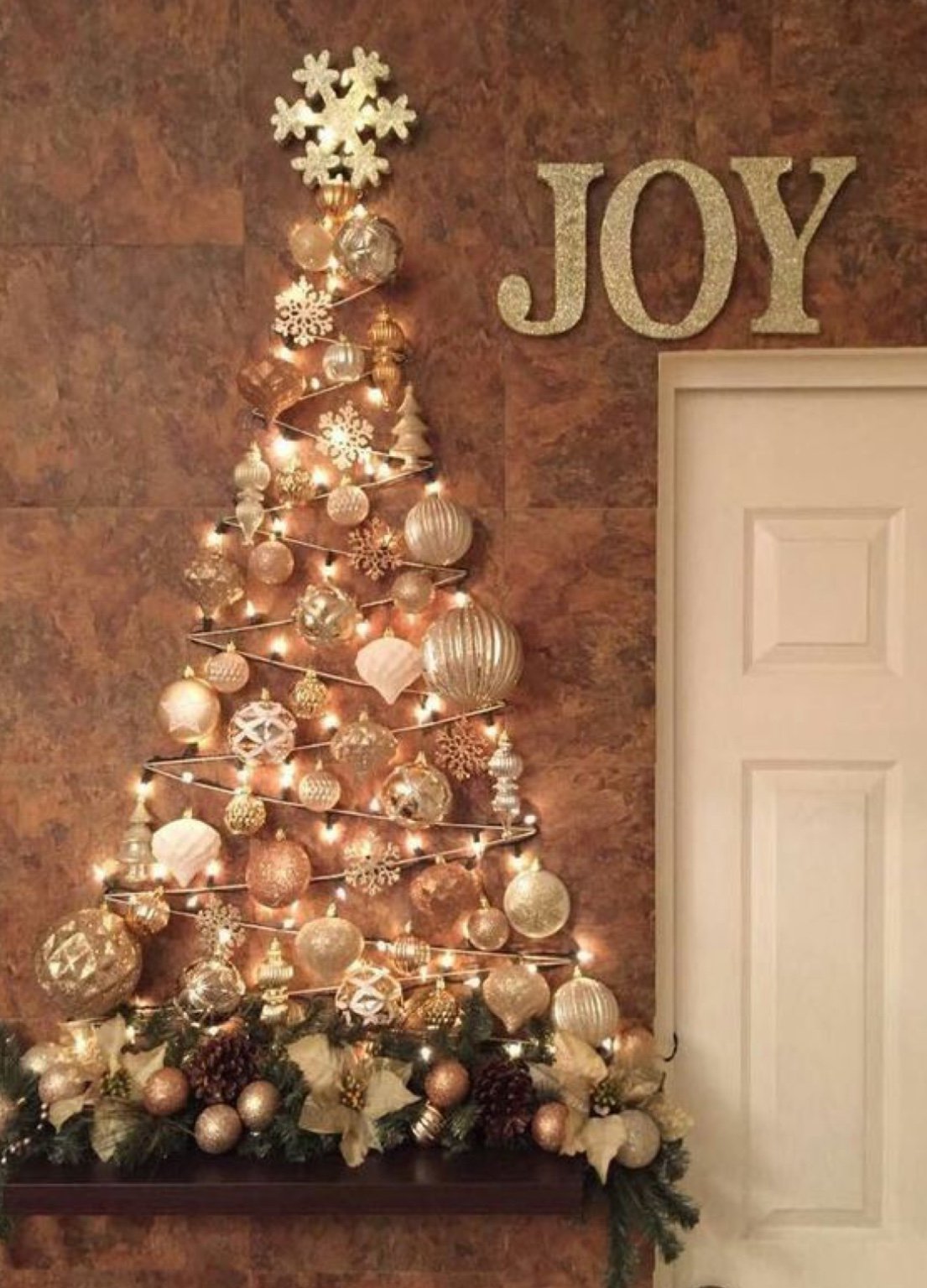 Árvore-de-Natal de parede feita de bolas natalinas douradas e peroladas