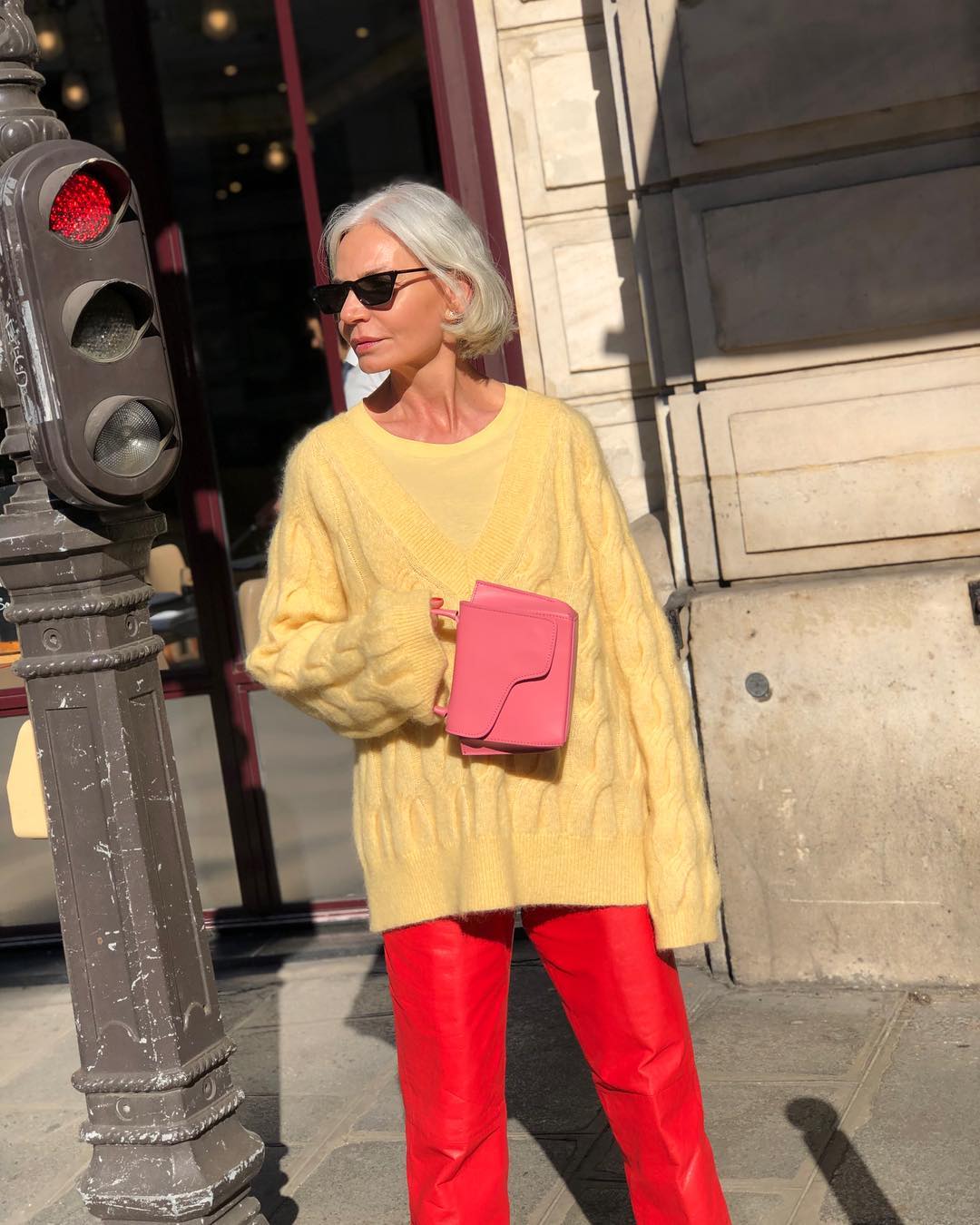 foto da influenciadora madura Grece Ghanem usando suéter amarelo com calça vermelha