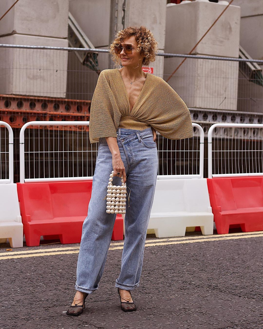 foto da influenciadora madura Renia Jaz usando blusa dourada com calça jeans