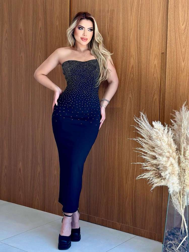 Mulher loira de pele clara com vestido midi azul com pedraria e salto alto preto