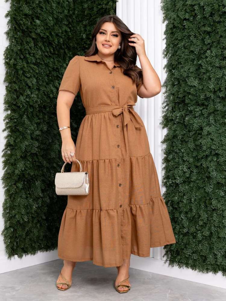 Mulher de pele clara com vestido midi marrom de linho e bolsa bege