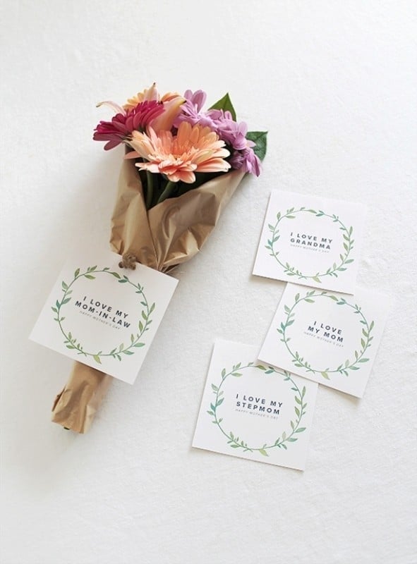 Buquê de flores envolto em papel marrom, com cartões ao lado