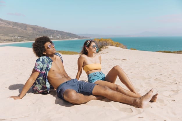 vitamina d homem e mulher tomando sol na areia