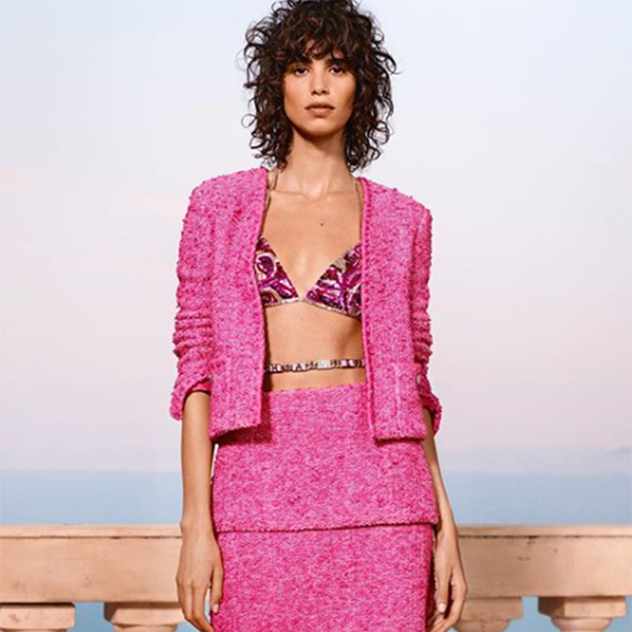 Foto de modelo com look pink trabalhado com casaqueto e top estilo curtinha bordado
