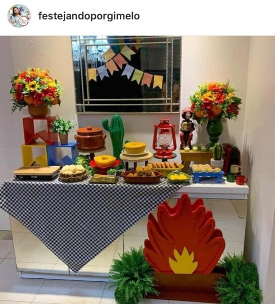 Foto do Instagram de aparador transformado em mesa de festa junina com toalha xadrez, comidinhas e decoração de bandeirolas e fogueira Foto de aparador transformado em mesa de festa junina com comidinhas e decoração de bandeirolas