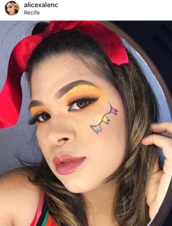 Make e penteado junino, com desenho de bandeirolas no lugar das tradicionais sardas