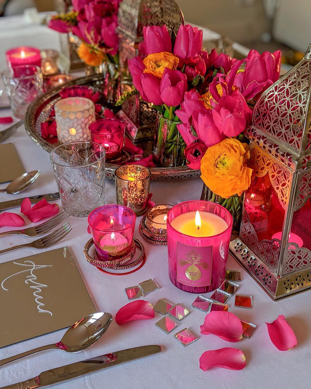 Foto de mesa decorada com rosas, pétalas e velas em tons de pink
