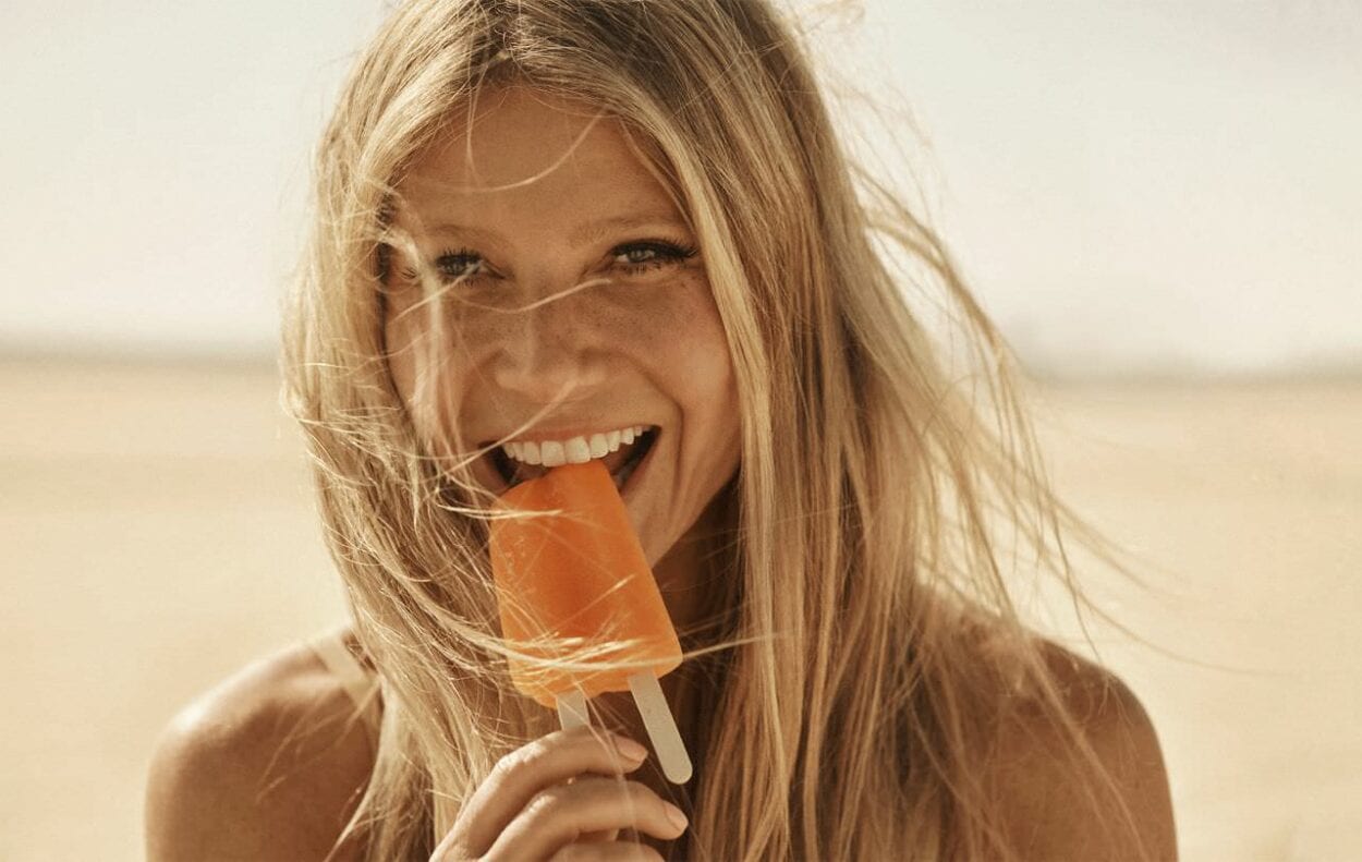 A atriz Gwyneth Paltrow em ensaio para a revista Shape. Aqui ela aparece com o cabelo no rosto e segurando um picolé de cor laranja A dieta polêmica de Gwyneth Paltrow