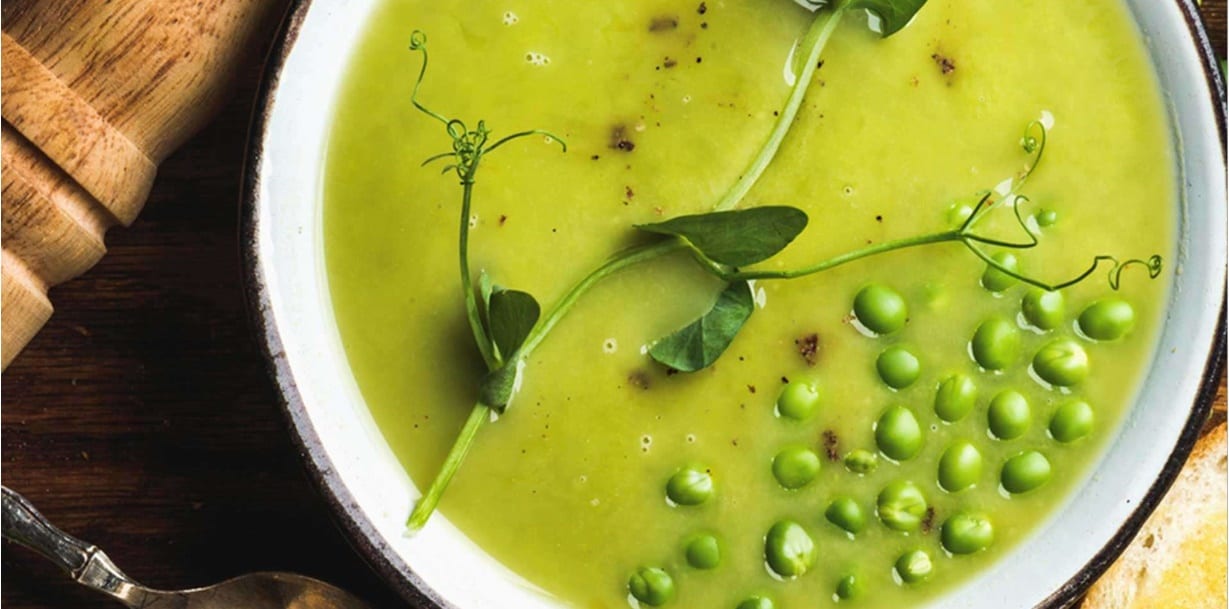 sopa de ervilha em recipiente branco em cima da mesa