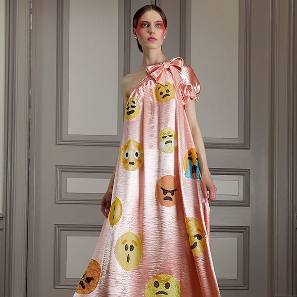 Modelo com Vestido camisola de cetim pessego e um ombro só com emogis da Viktor & Rolf - Inverno 2021 Vestido camisola pêssego com emogis da Viktor & Rolf - Inverno 2021