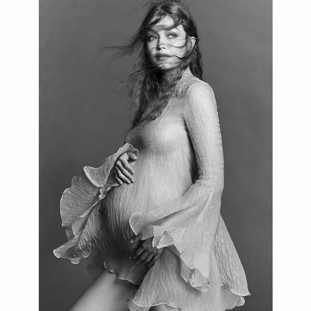 Foto da mamãe com mãos na barriga grávida.