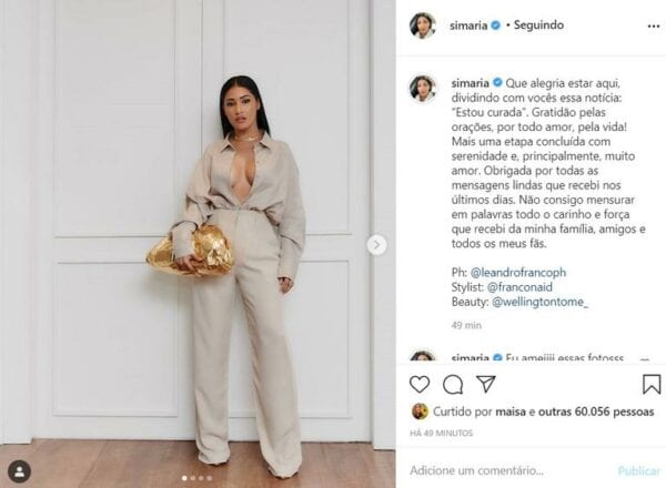 Simaria aparece em foto publicada em seu Instagram. Aqui usa um conjunto de calça e camisa bege, com decote aberto e com uma bolsa dourada de mão Simaria está curada da covid-19!