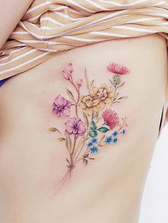 Buquê colorido de flores na lateral do corpo